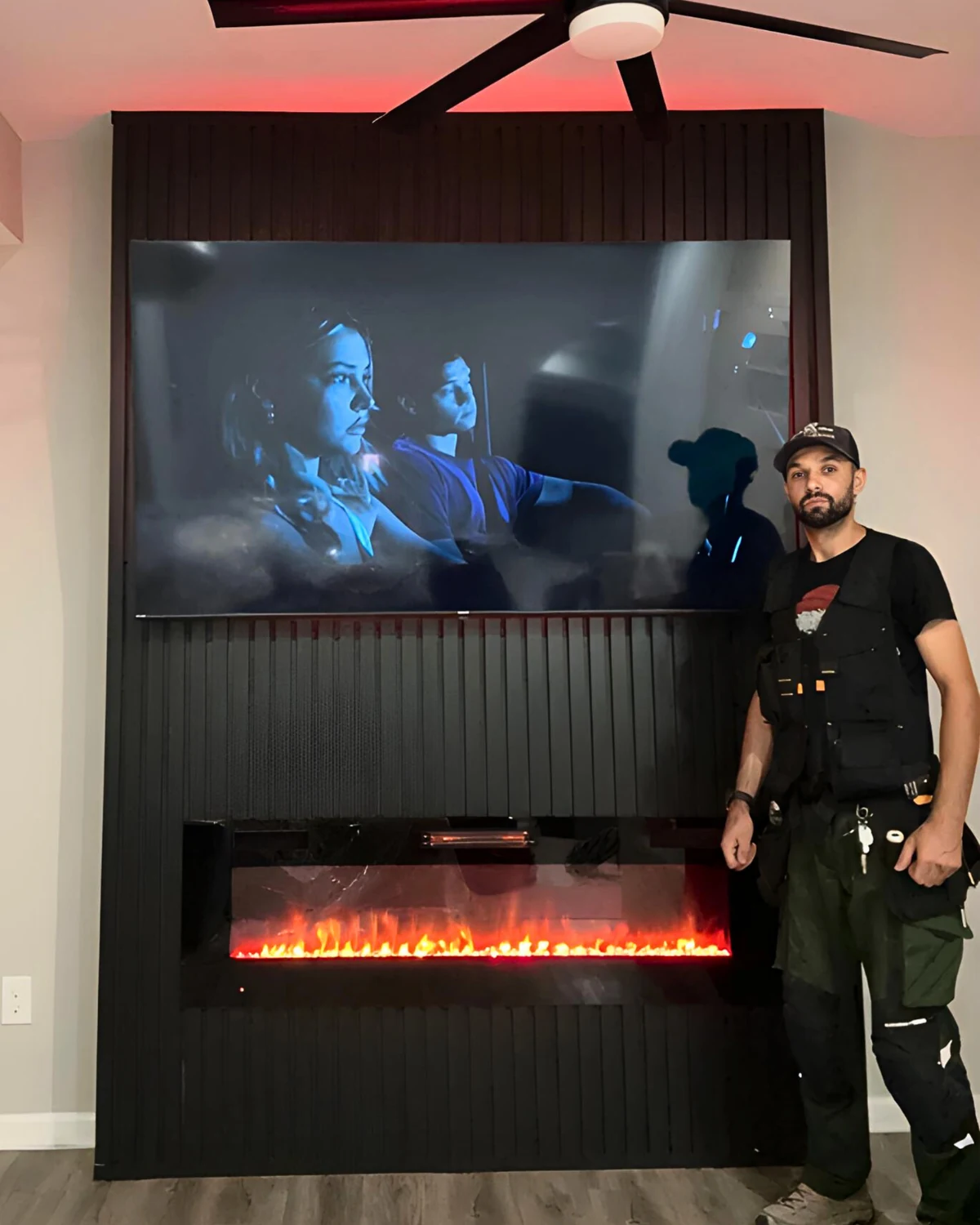 Roman beside a completed black slat fireplace feature wall with mounted TV and linear electric fireplace