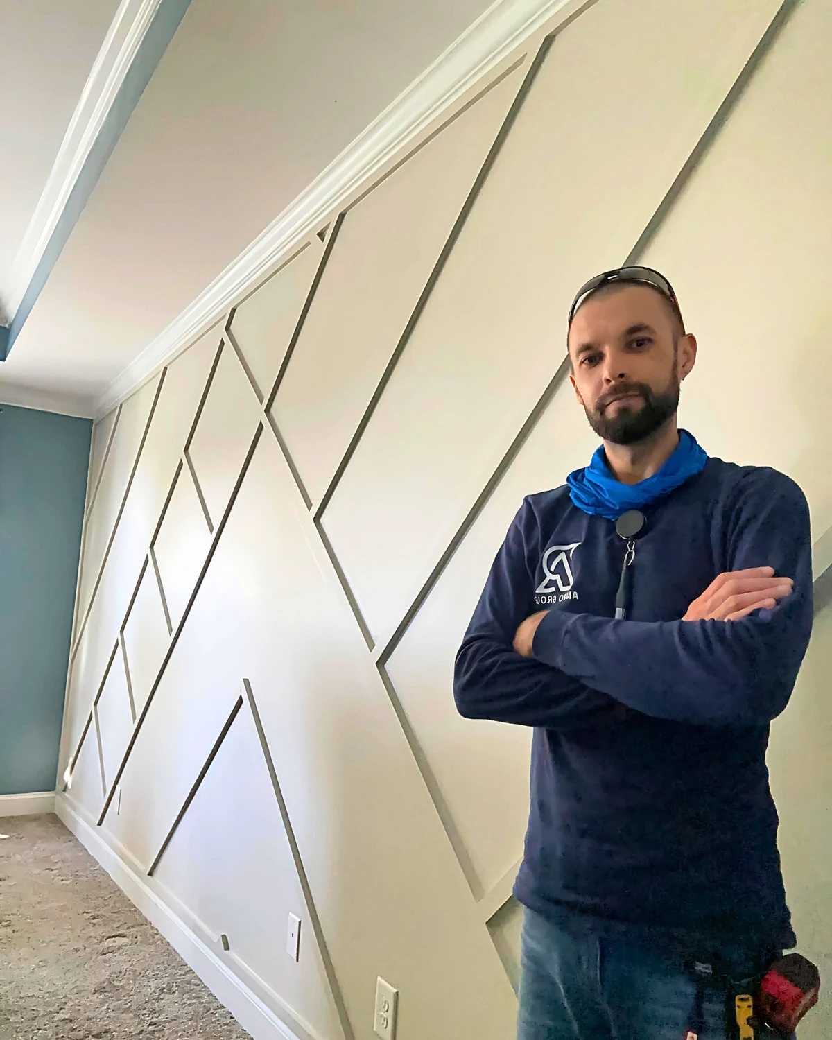 Roman beside a completed modern geometric accent wall with custom trim layout
